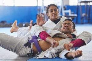 Cropped shot of two young martial artists practicing jiu jitsu in the gym.