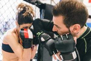 mma training. couple making sparring in the mma cage. concept about fighting, fitness and sport