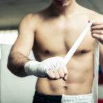 Fighter putting bendage on the hands before training